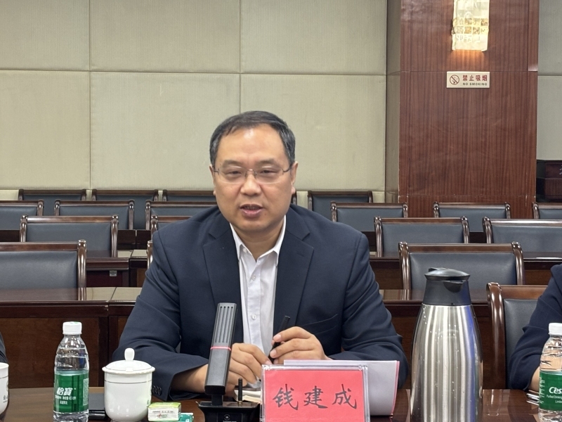 桌子前坐着穿西装的男人  中度可信度描述已自动生成